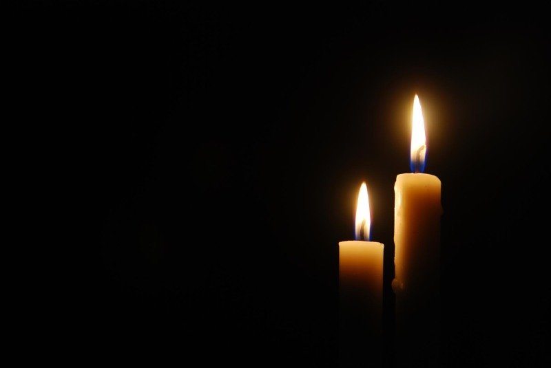 Close-up of lit candle in darkroom