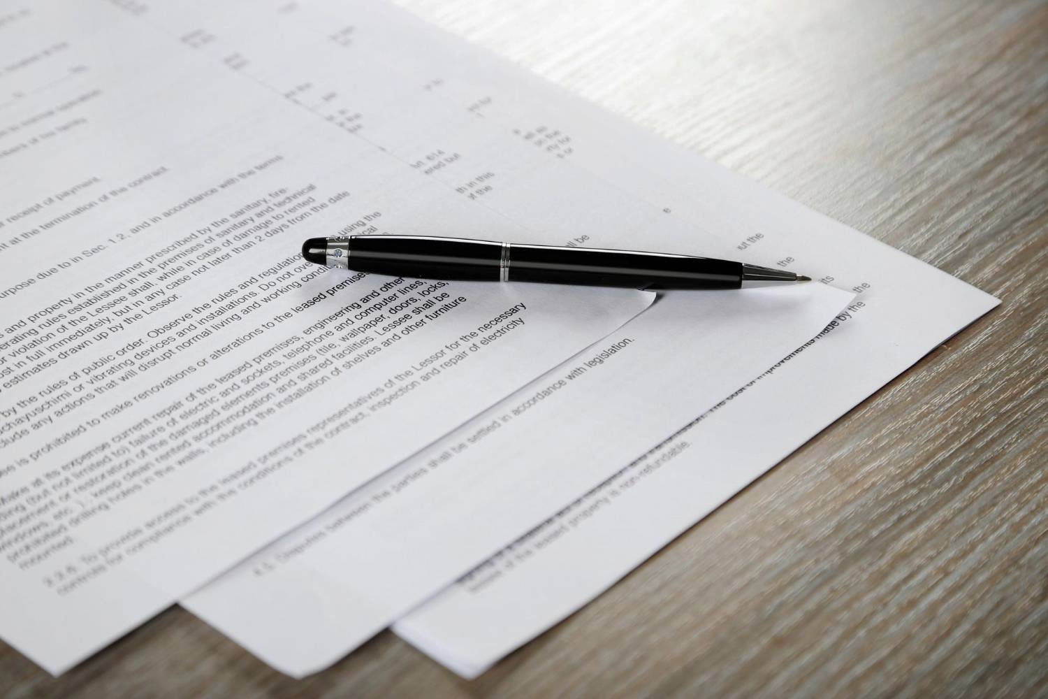 Documents and pen on wooden background