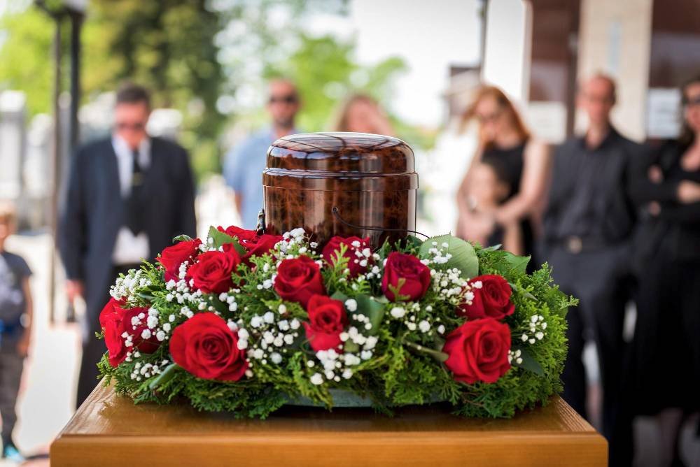urn with ashes of dead and flowers at funeral
